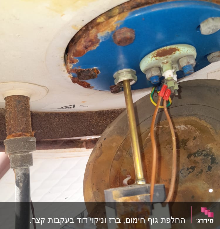 חלק תחתון של דוד שמש עם חלודה וחיבורים חשמליים